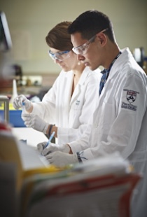 Two people working in lab wearing white coats